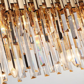 Close-up of a luxurious Gio crystal dining room chandelier from Morsale.com with gold accents, showcasing detailed prism designs and light refractions creating rainbow effects.