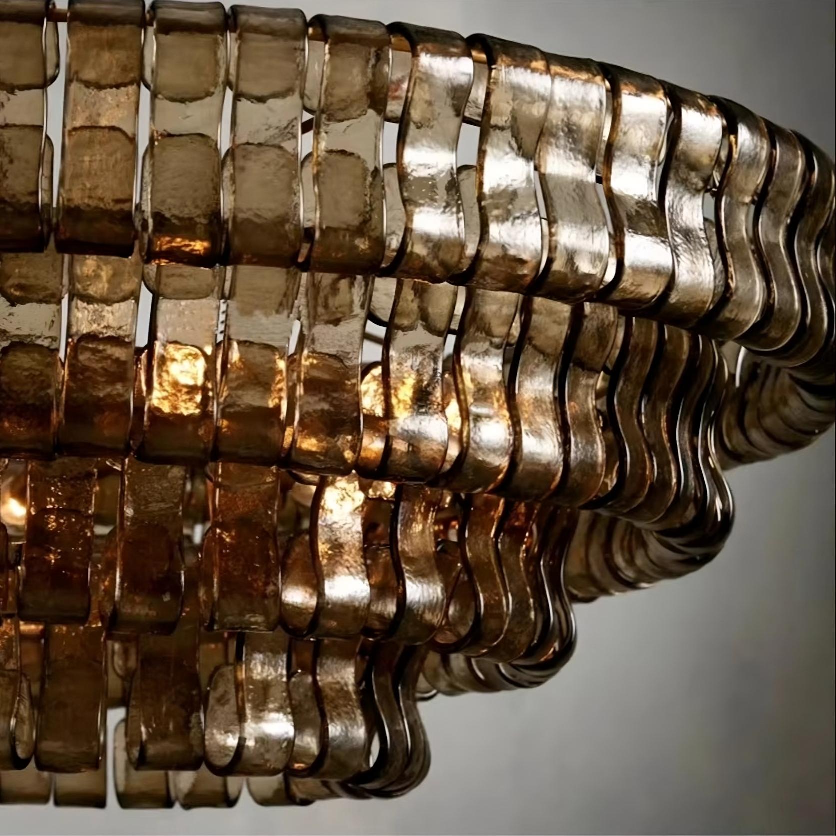 Close-up of the Riviera Vintage French Crystal Chandelier by Morsale, featuring multiple wavy, translucent glass pieces in horizontal rows that glow warmly from the elegant lighting within.