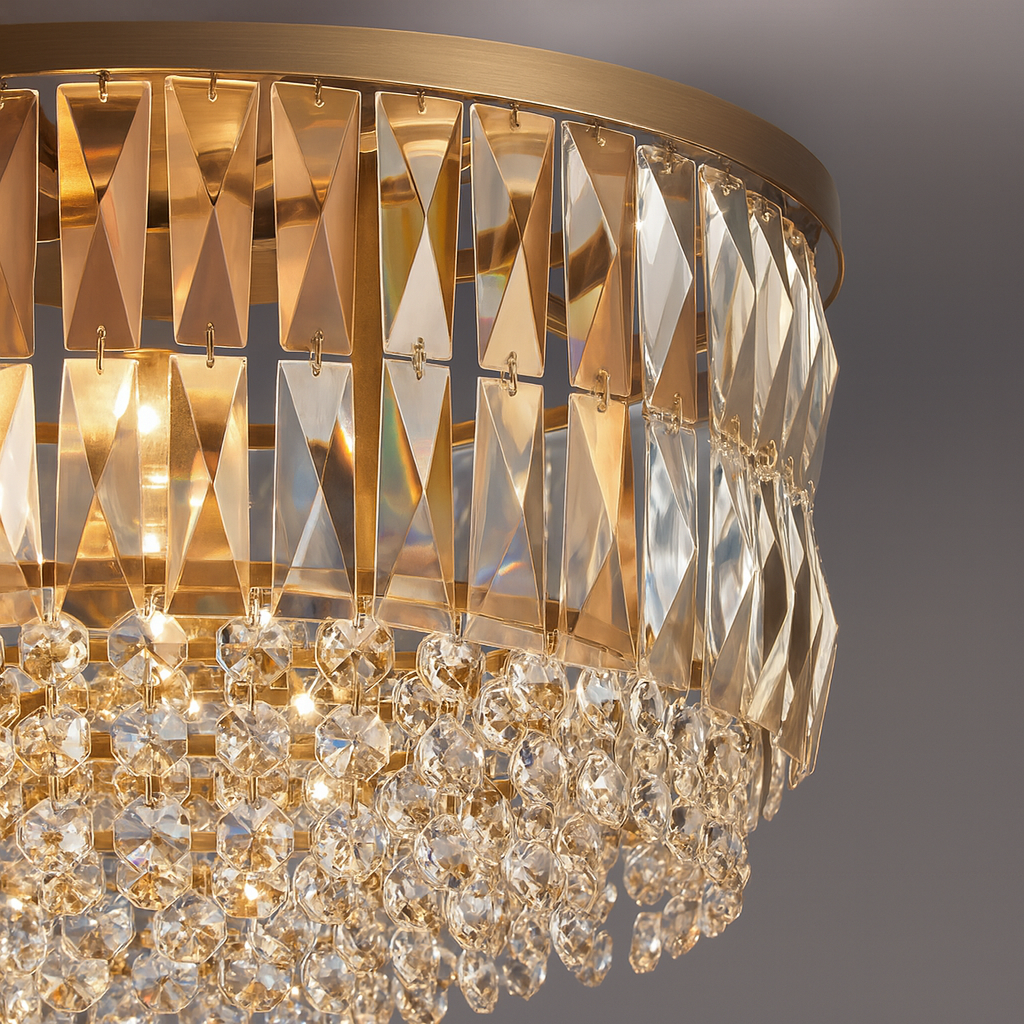 A close-up of the Bacci Crystal Round Chandelier by Morsale.com, featuring gold geometric panels and precision-cut crystal prisms that reflect warm, ambient light against a soft gray background.