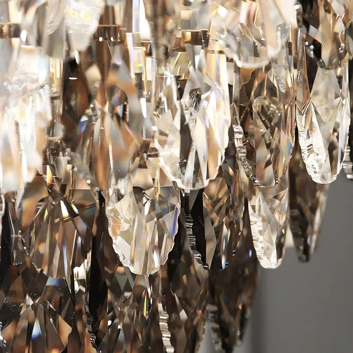 Close-up of hand-cut crystals on the Morsale Langford Luxury Dining Room Chandelier, reflecting light for a shimmering effect. A softly blurred background highlights the intricate crystal details and modern stainless steel design.