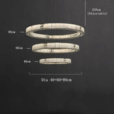 The Marble & Crystal Modern Chandelier by Morsale.com has three horizontal, circular LED light rings. The largest ring has a diameter of 80cm, the middle ring 60cm, and the smallest ring 40cm. The height is adjustable up to 250cm. This LED ceiling chandelier features rings suspended at varying heights in a staggered formation.