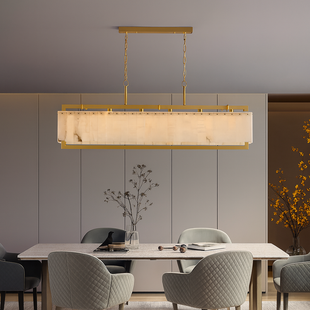 A modern dining room showcases the Morsale Stanton Brass & Marble Dining Chandelier above the table. Four upholstered chairs encircle the table, while a branch with yellow flowers brightens the right corner.