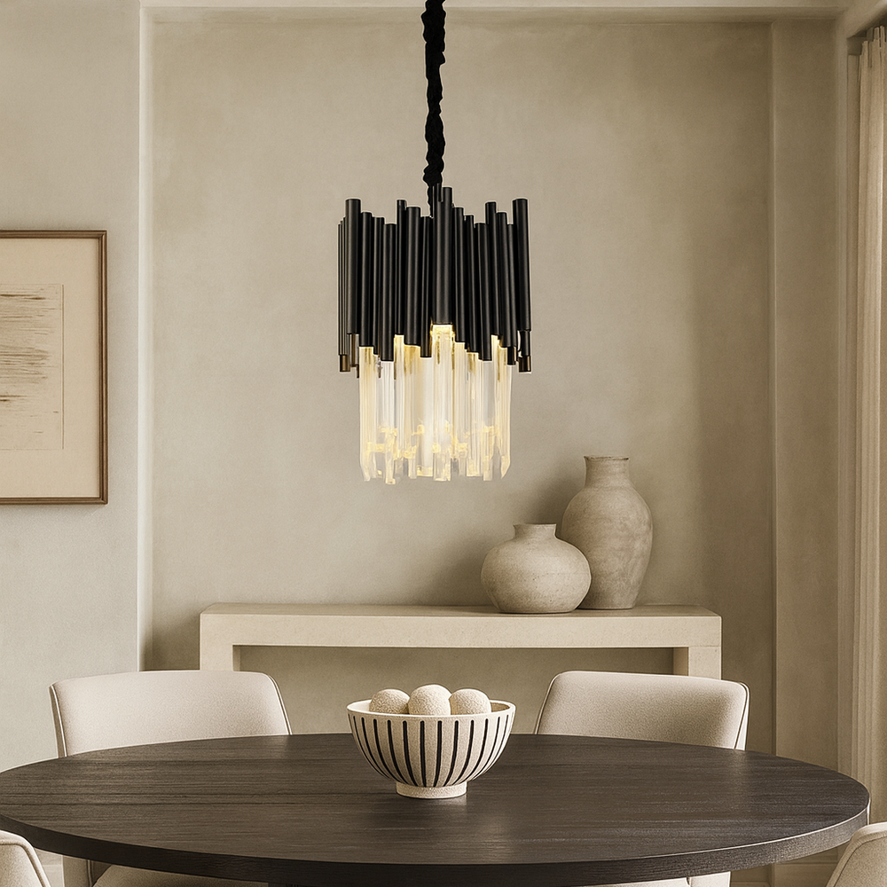 A modern dining room features a round table, four cream chairs, a striped bowl with white decorative balls, ceramic vases on a console, and the Vigo Crystal Round Chandelier 12" by Morsale.com as a striking centerpiece.