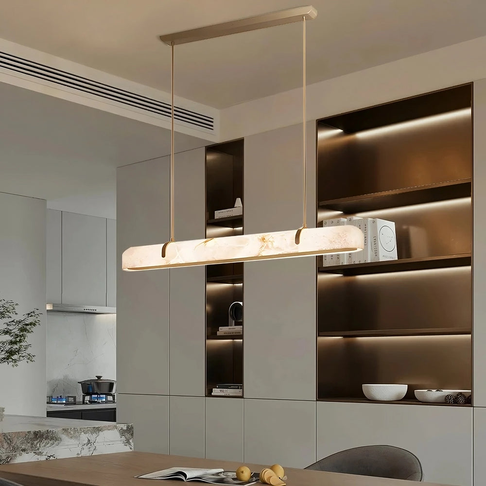 
                  
                    A modern dining room showcases a Morsale Linea Marble & Copper Linear Pendant with integrated LED above the table, while built-in shelves with warm lighting and decorative items create an inviting backdrop.
                  
                