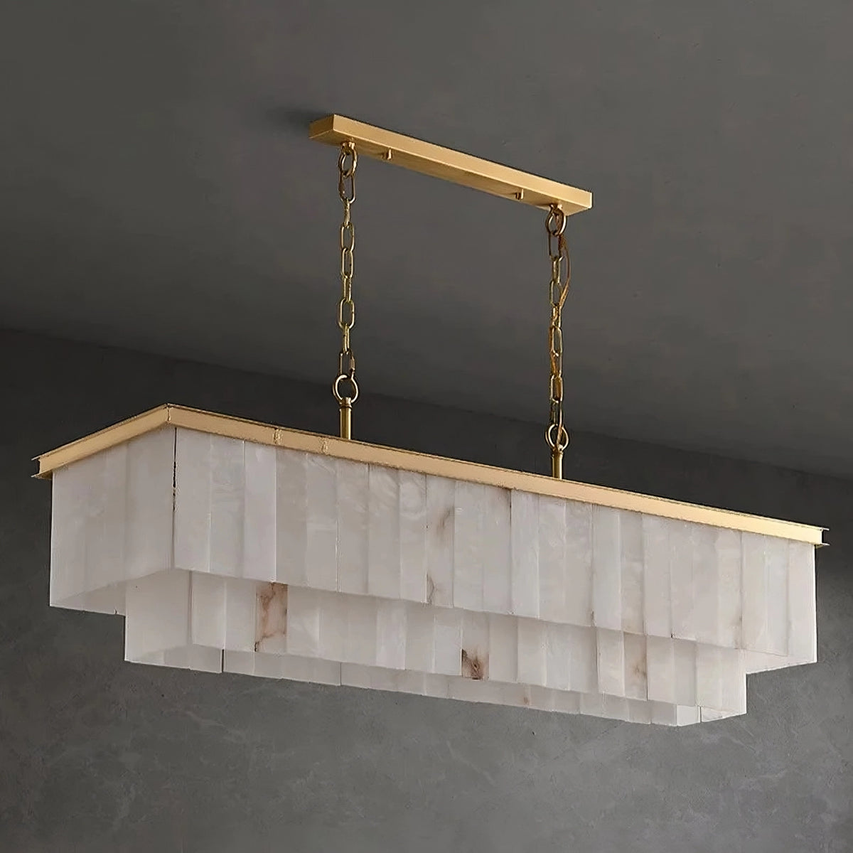 A modern rectangular Shopp578 Natural Calcite Dining Room Chandelier with a brass frame and chains, featuring cascading layers of translucent natural calcite or glass panels. It hangs from a matching gold ceiling mount against a dark gray background.