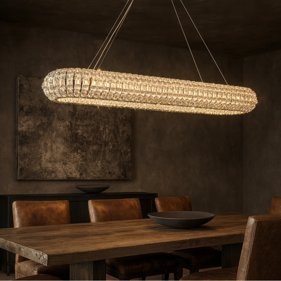 Modern chandelier hanging above a wooden dining table in a dimly lit room.