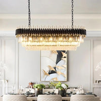 A modern dining room features the Verano Luxury Dining Room Chandelier from Morsale.com, a large rectangular dimmable crystal fixture hanging above a table for six, with a gray wall and gold-accented bird art in the background.