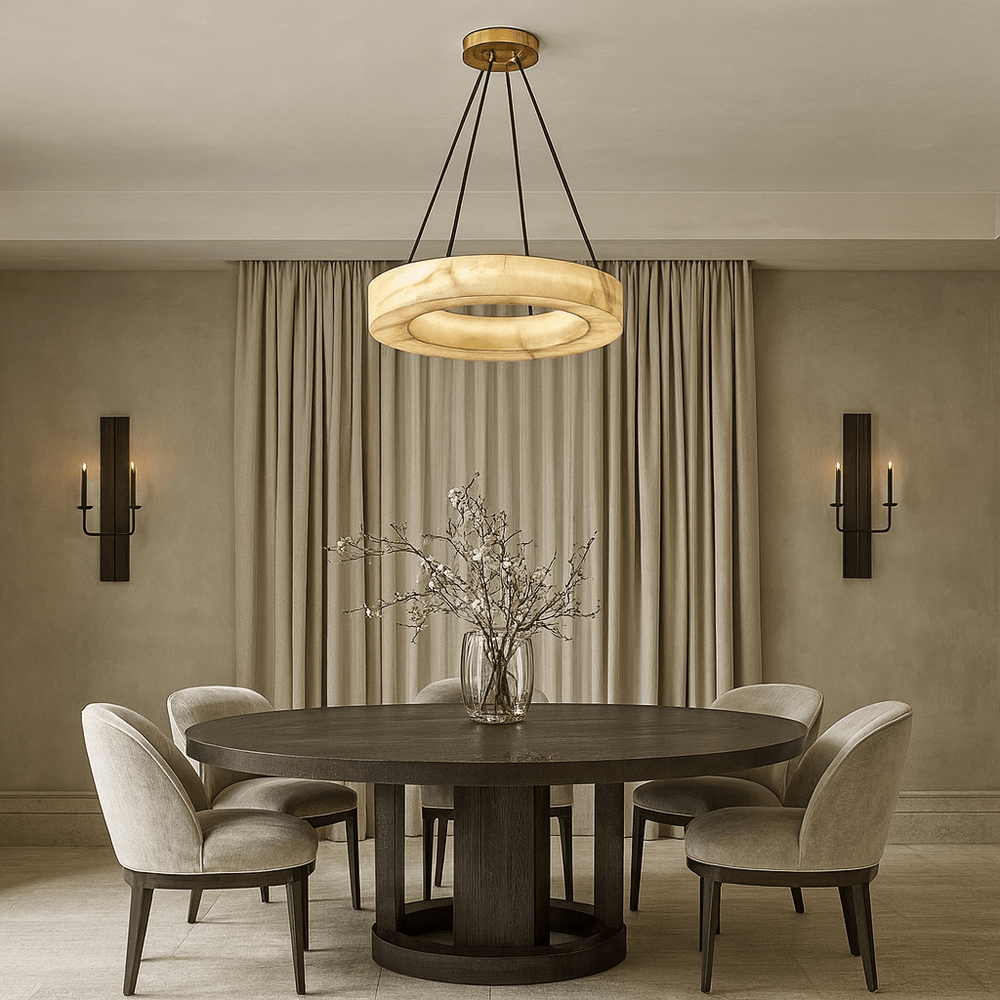 A modern dining room with a round dark wood table, five upholstered chairs, a glass vase with branches, beige curtains, two wall sconces with candles, and the elegant Palmer Marble Chandelier by Morsale overhead.