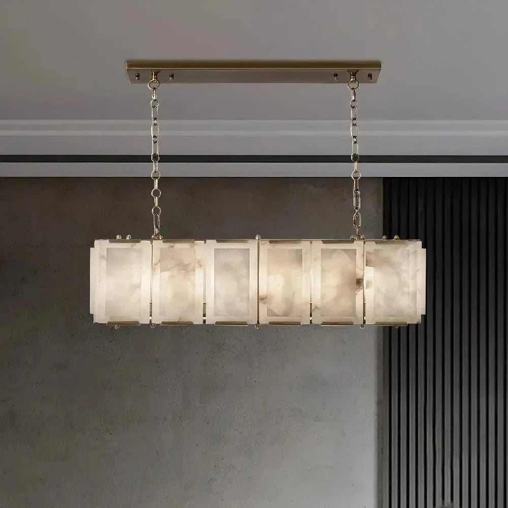 A 40" Natural Marble Rectangular Chandelier with five alabaster shades suspended by chains from a brass bar, featuring Spanish imported marble, set against a gray concrete wall by Morsale.