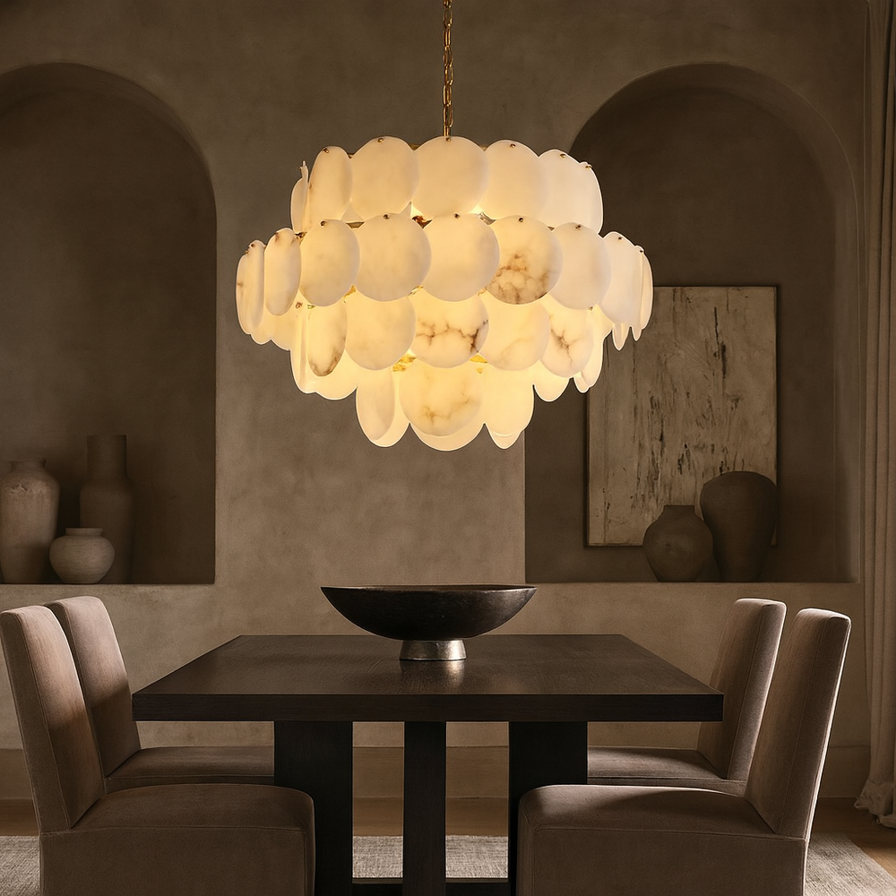 A modern dining room features a dark wood table, two brown chairs, a decorative bowl, and the striking Bordwell Marble Chandelier 31" by Morsale.com. Neutral-toned vases and abstract art accent the alcoves behind.