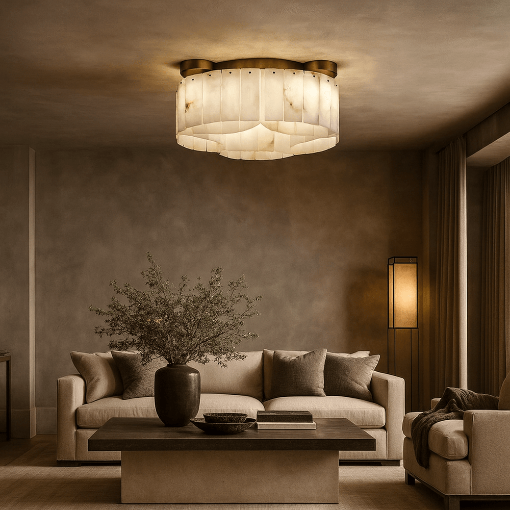 A modern living room with neutral tones, featuring a beige sofa, armchair, dark wood coffee table, potted plant, floor lamp, and the Milton Marble Flush Mount by Morsale.com, casting a warm glow from the ceiling.