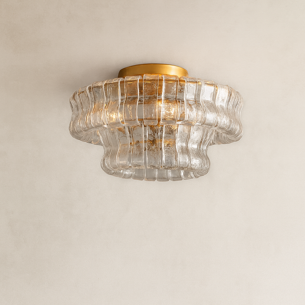 Ceiling light fixture with glass shade and gold trim on a beige wall