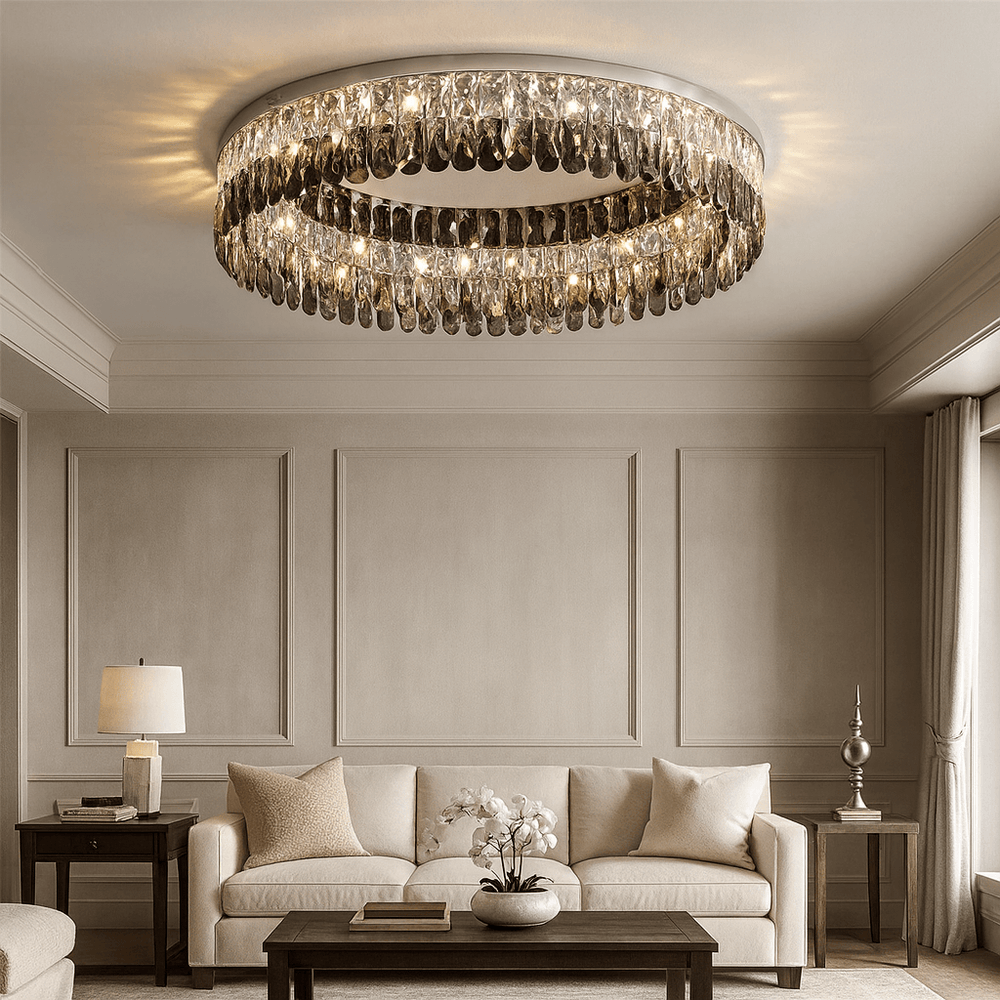 Elegant living room with beige walls and furniture, a round glass coffee table with white orchids, and the Giano Crystal Flush Mount by Morsale.com featuring smoke grey crystals, creating a luxurious and cozy atmosphere.