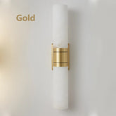 A modern Natural Marble Indoor Wall Sconce Light by Morsale.com with a sleek white cylindrical shade and a central gold metallic band is mounted on a white wall. Incorporating natural marble, this indoor sconce exudes a minimalist and elegant design. The word "Gold" is displayed on the left side of the image.
