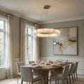 Modern dining room with wooden table, chairs, and abstract art on the wall.