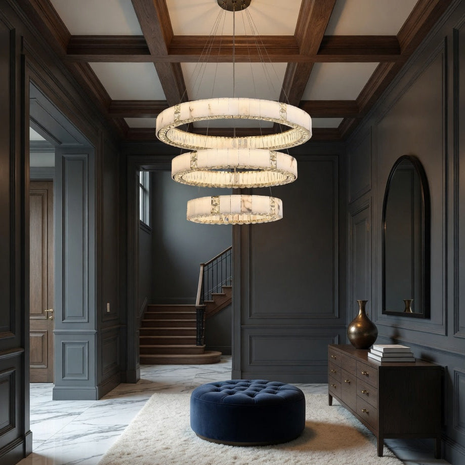 Luxurious interior with a chandelier, blue ottoman, and marble floor.