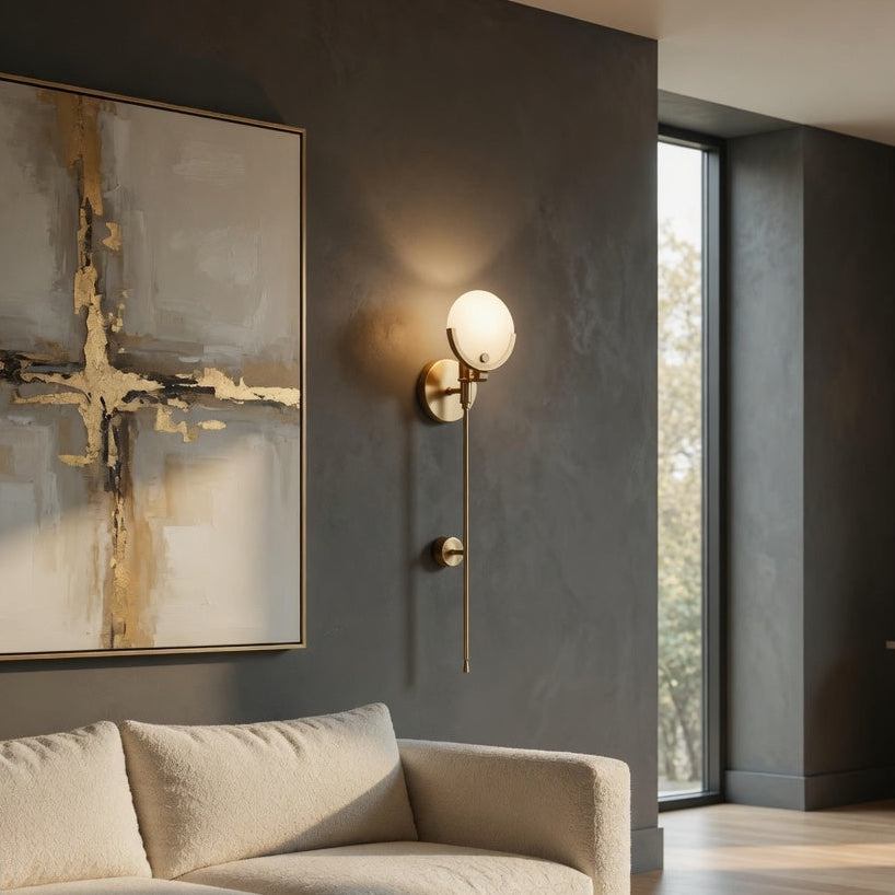 Modern living room with a beige sofa, abstract painting, and wall sconce.