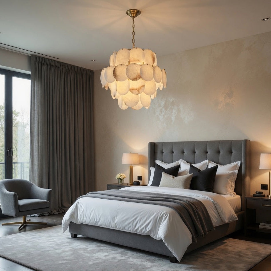 Modern bedroom with a gray upholstered bed, stylish chandelier, and large windows.