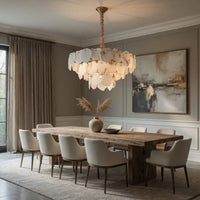 Dining room with wooden table, white chairs, and a modern chandelier.