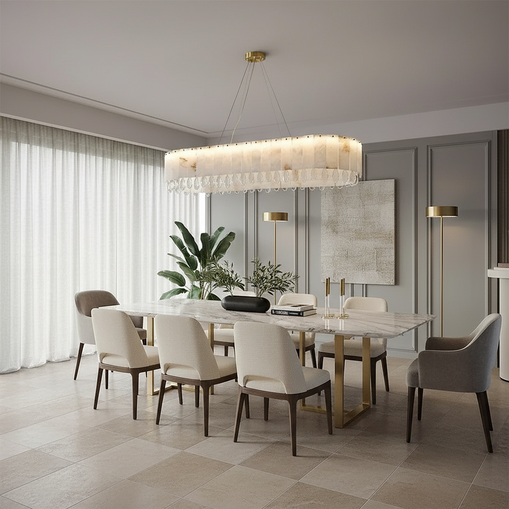 A modern dining room features a marble table, beige and gray chairs, gold accents, plants, sheer curtains for natural light, floor lamps, and the Morsale Oraria Marble & Crystal Dining Chandelier.