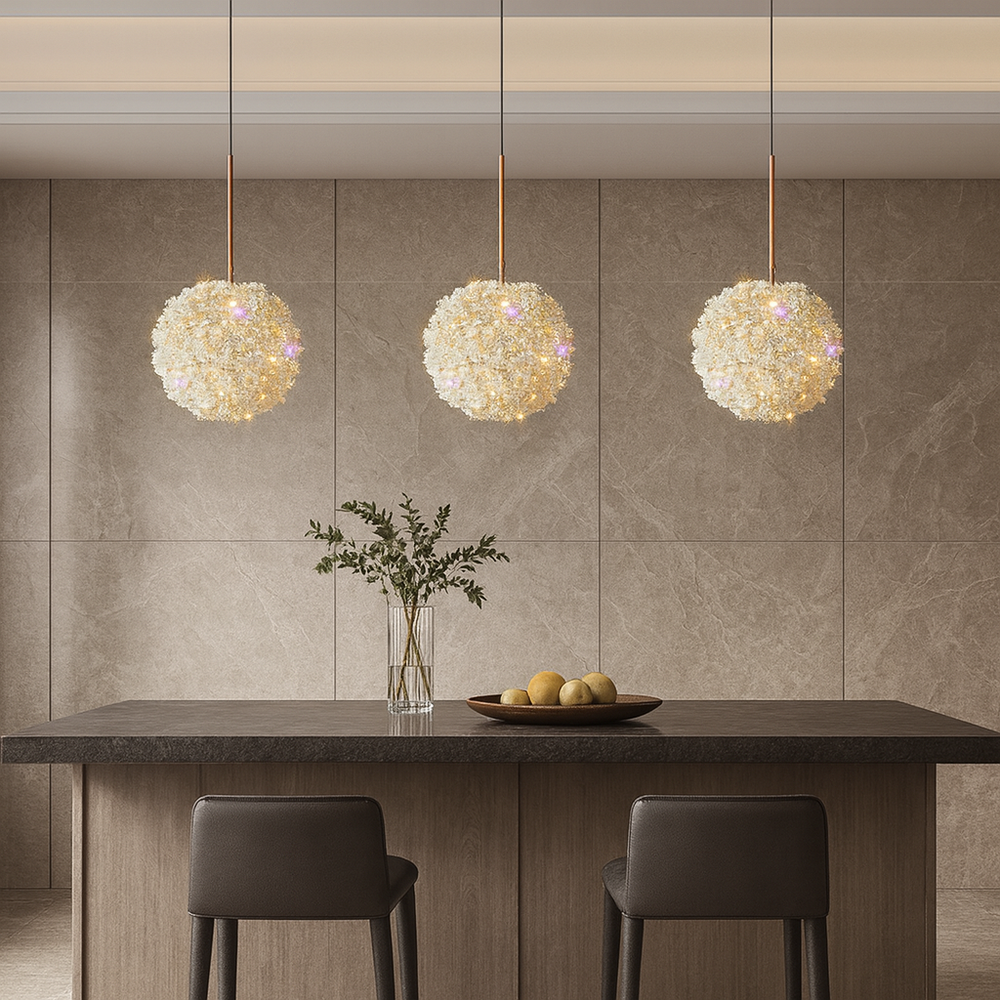 Three decorative pendant lights hanging above a dining table with a vase and fruit bowl.