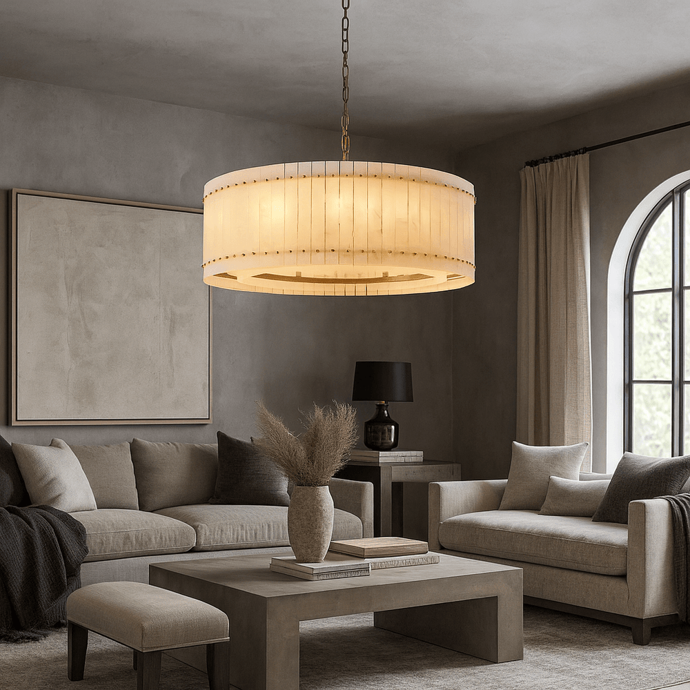 
                  
                    A modern living room with neutral tones features a Morsale Valmont Marble Round Chandelier 39", beige sofas, a square coffee table with dried grass in a vase, wall art, a black table lamp, and an arched window with beige curtains.
                  
                