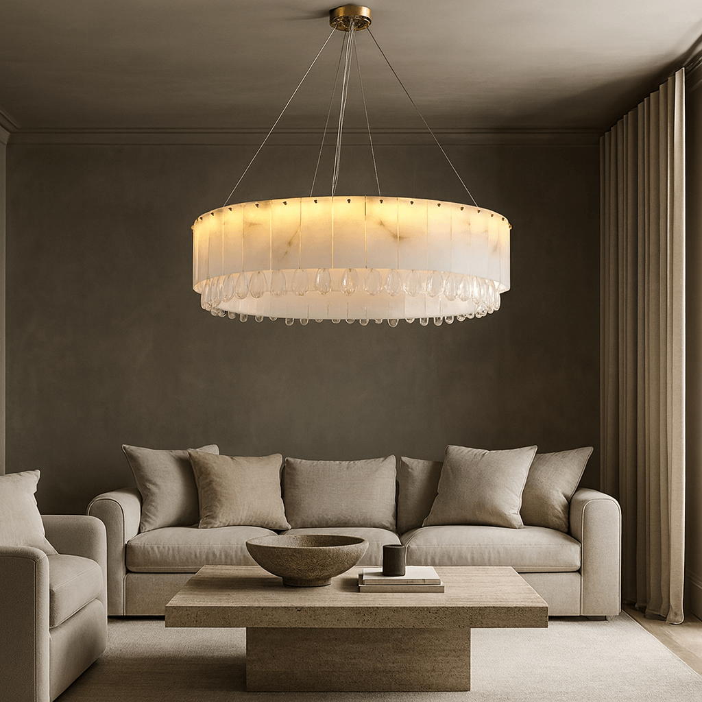 A modern living room features beige sofas, a wooden coffee table, and the Stuart Marble & Crystal Chandelier 39" by Morsale.com. Neutral tones and contemporary luxury lighting create a cozy, minimalist atmosphere.