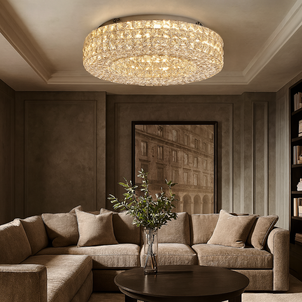 
                  
                    A modern living room features a large beige sectional sofa, a round wooden coffee table with a vase of greenery, and the elegant Morsale Bacci Crystal Flush Mount LED ceiling light. Neutral walls and framed art add to the cozy, sophisticated vibe.
                  
                