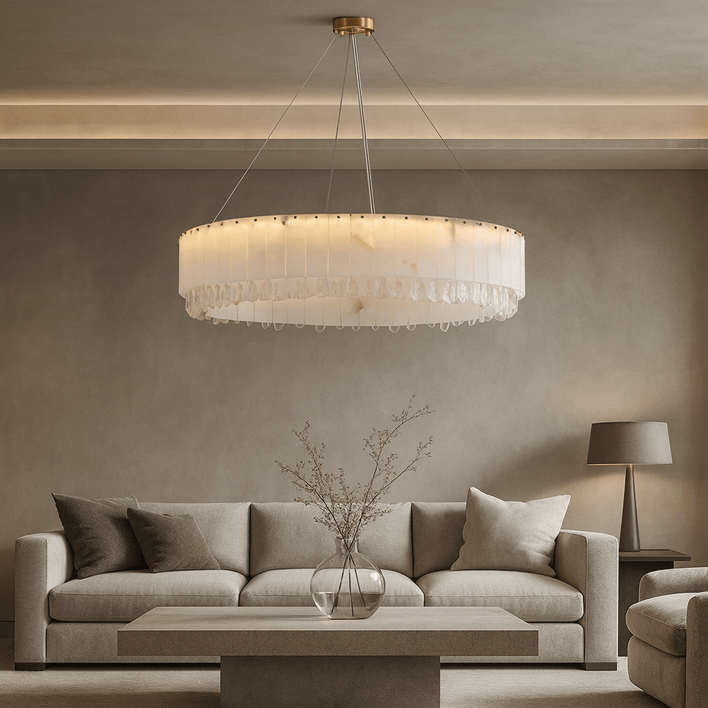 A modern living room features a beige sofa, a square coffee table with a glass vase of twigs, a floor lamp, and the Stuart Marble & Crystal Chandelier 39' by Morsale.com casting soft light from the ceiling.
