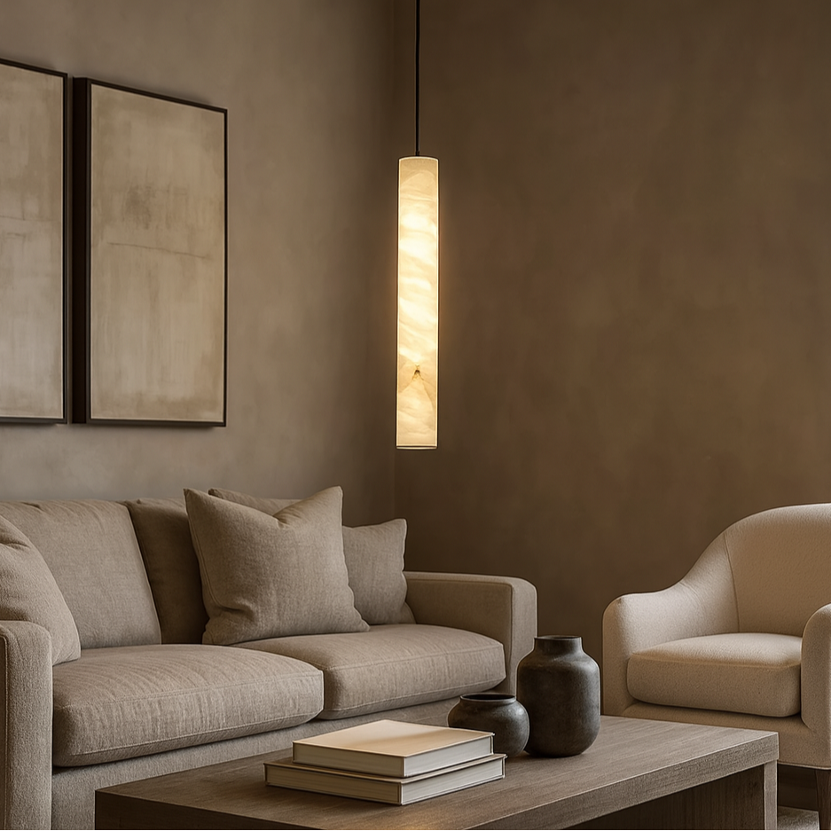 
                  
                    A modern living room with a beige sofa, armchair, wooden coffee table topped with vases and books, abstract wall art, and Morsale's Moonshade Marble Pendant Lights—cylindrical dimmable LEDs with a warm glow—all in neutral tones.
                  
                