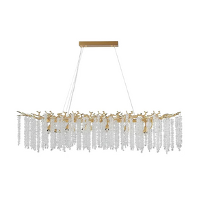 A modern, rectangular Albero Kitchen Ceiling Light Fixture from Morsale.com hangs above a dining table, featuring cascading crystal-like elements and multiple light bulbs. The room has a minimalist design with neutral tones, and a bowl of fruit can be seen on the table below the chandelier.