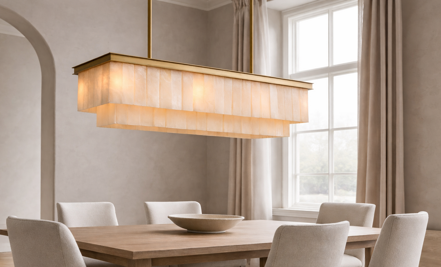 Dining room with a modern chandelier, wooden table, and beige chairs.