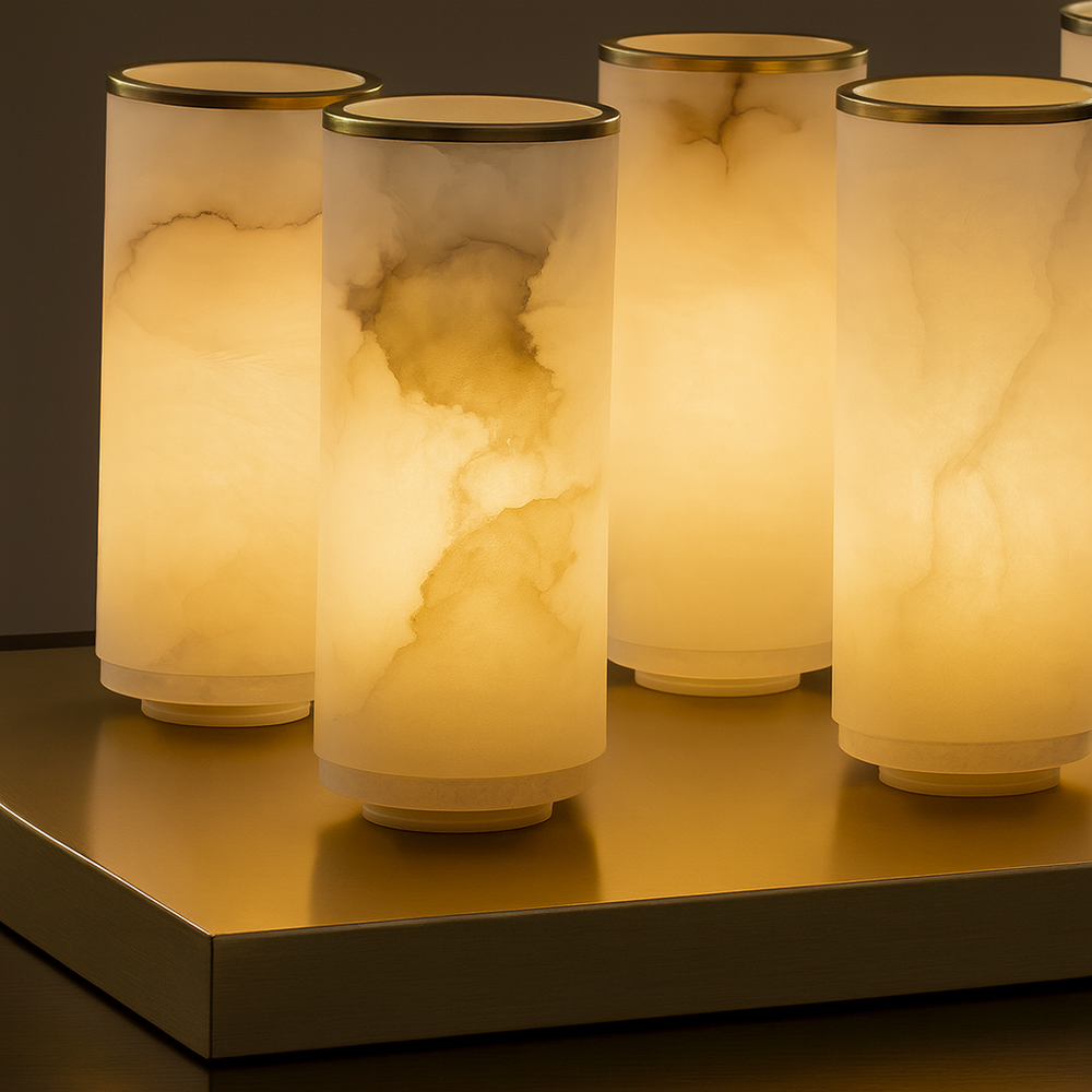 
                  
                    Five Aurelia Natural Marble Wall Sconces by Morsale.com display marble-patterned shades emitting a warm yellow glow, arranged close together on a reflective surface for a modern, elegant look against a neutral background.
                  
                