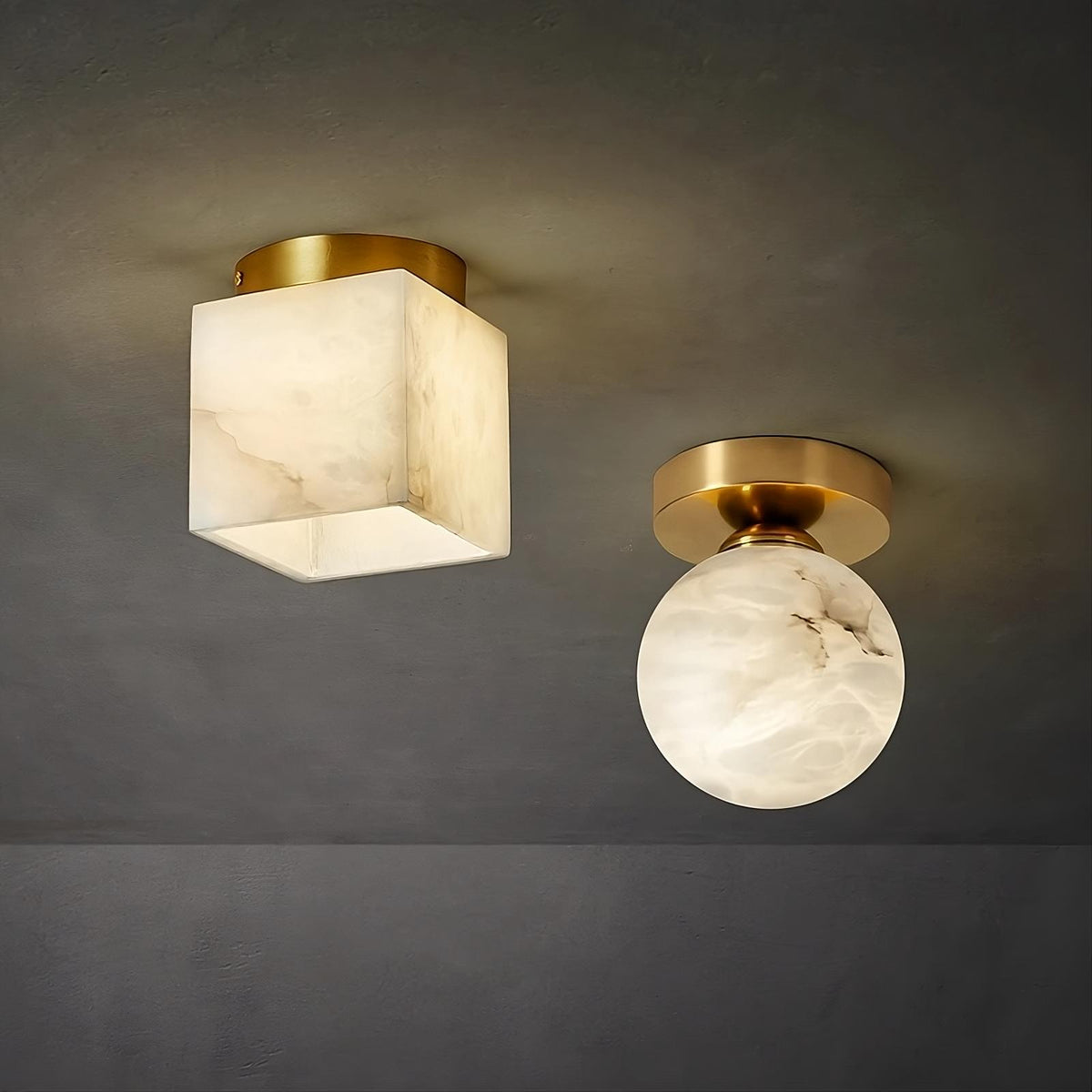 An image showing two ceiling lights with a modern design. One **Natural Marble Hallway Ceiling Light Fixture** by **Morsale.com** has a cube-shaped frosted shade, and the other has a round frosted shade. Both lights have gold-toned fixtures and are mounted on a dark gray ceiling.