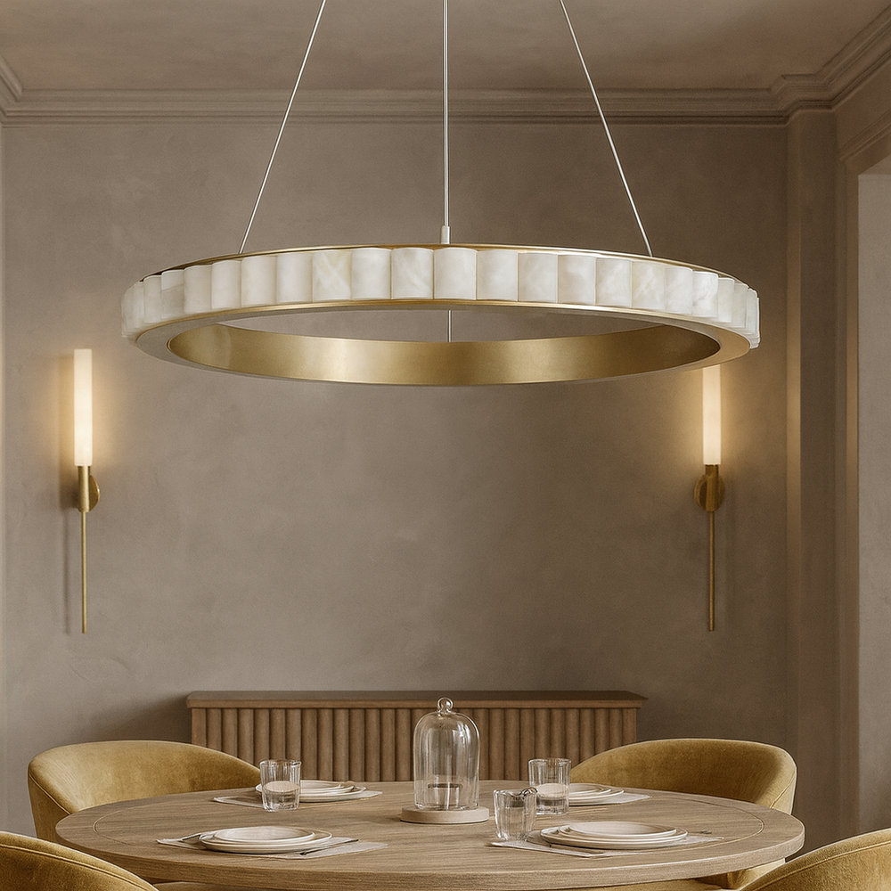 A modern dining room features a round wooden table for four with velvet chairs. Overhead, the Bigman Hampton Marble Chandelier with integrated LED ceiling light glows, complemented by two wall sconces for soft lighting.
