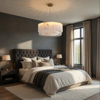 Modern bedroom with a large bed, gray headboard, and decorative lighting fixture.
