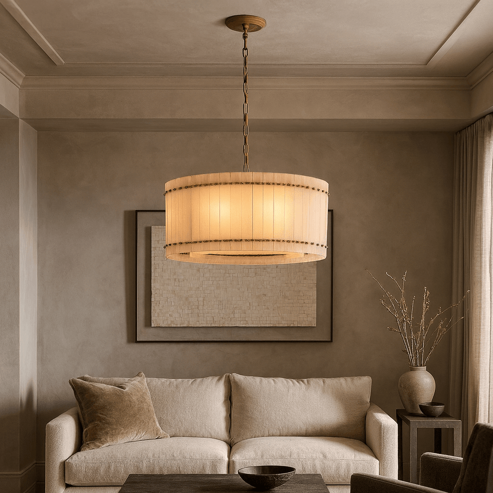A beige living room features a plush cream sofa, round wooden coffee table, tall vase with twigs, and the Morsale Valmont Marble Round Chandelier 24" hanging above. Neutral wall art adds to the serene atmosphere.