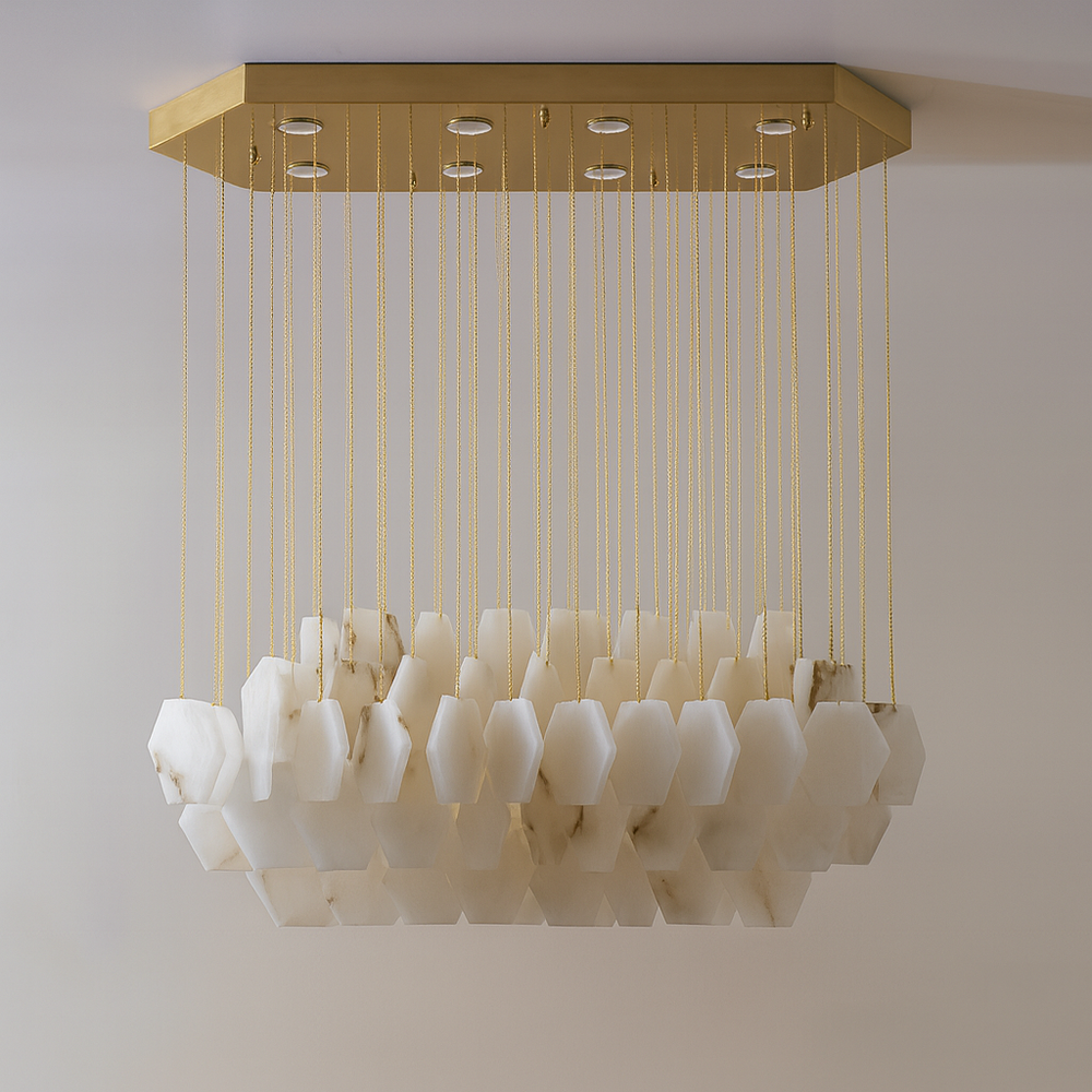 
                  
                    The Arden Marble Chandelier by Shopp578 features hexagonal white alabaster pieces suspended from thin gold cables and a brass chain, all attached to a rectangular gold ceiling mount.
                  
                