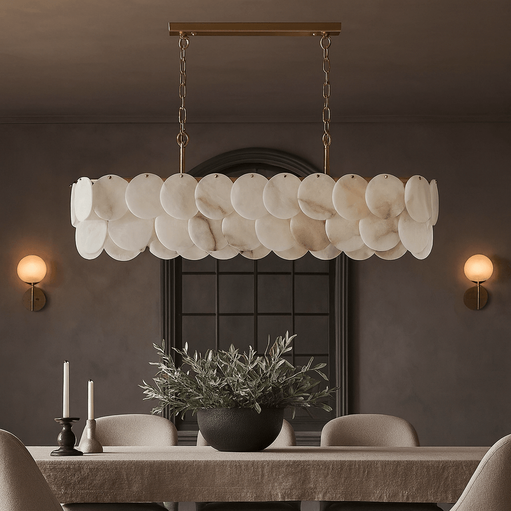 A modern dining room highlights the Morsale Bordwell Marble Dining Room Chandelier 47" above a rectangular table with candles, a potted plant, neutral chairs, and two wall sconces on dark walls.