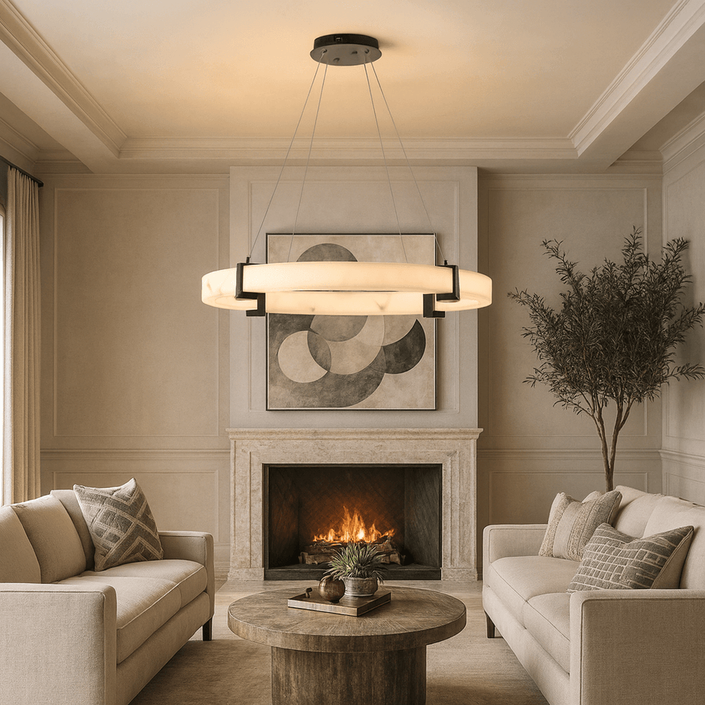 A modern living room features two beige sofas, a round wooden coffee table, a fireplace with geometric art above, the Morsale Chester Marble Ring Chandelier overhead, and a potted tree in the corner for greenery.