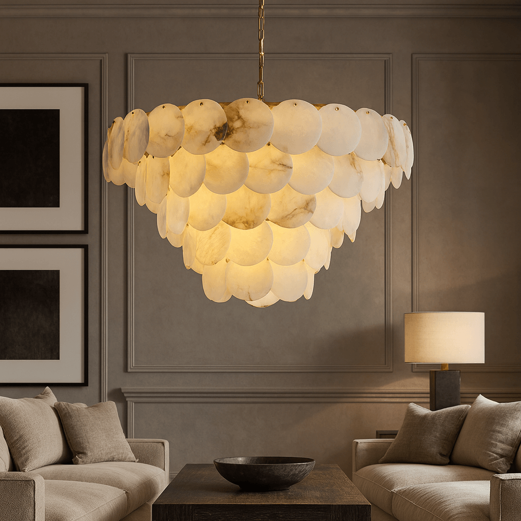 The Bordwell Marble Chandelier 35" by Morsale.com, with layered translucent discs, hangs above a modern living room featuring beige couches, neutral pillows, a table lamp, and minimalist wall art.