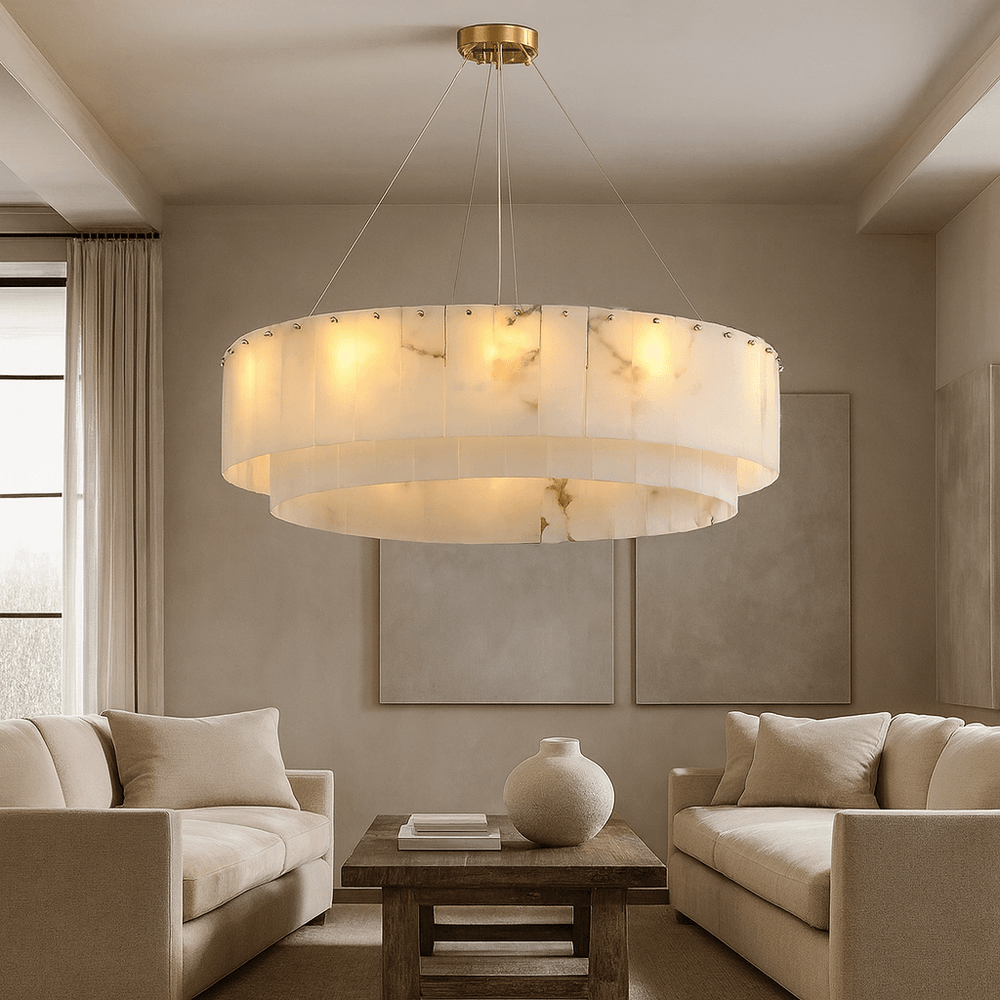 A modern living room features two beige sofas, a wooden coffee table with a white vase, and the Buckley Marble Modern Chandelier by Bigman. Neutral walls and artwork complete the calm, elegant atmosphere.