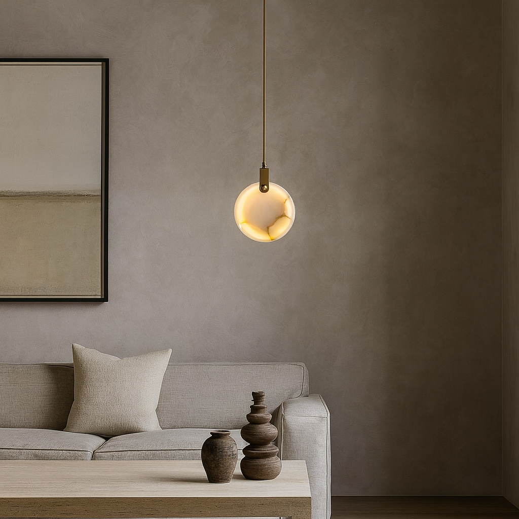 A minimal living room features a beige sofa with a cushion, a wooden coffee table with ceramic vases, the Moonshade Natural Marble Pendant Light by Morsale.com, and a large abstract painting on a neutral wall.