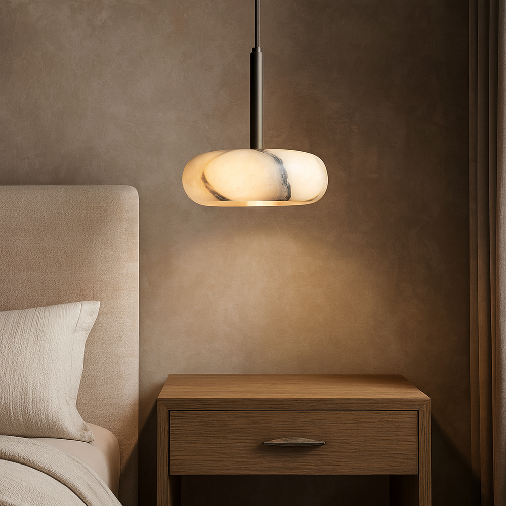 A modern bedroom featuring a beige upholstered bed, a wooden nightstand, and the Morsale Luna Natural Marble Pendant glowing softly against a textured brown wall.