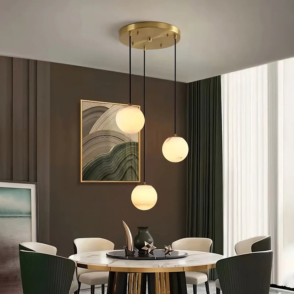 
                  
                    Modern dining room with pendant lights, round table, and chairs.
                  
                