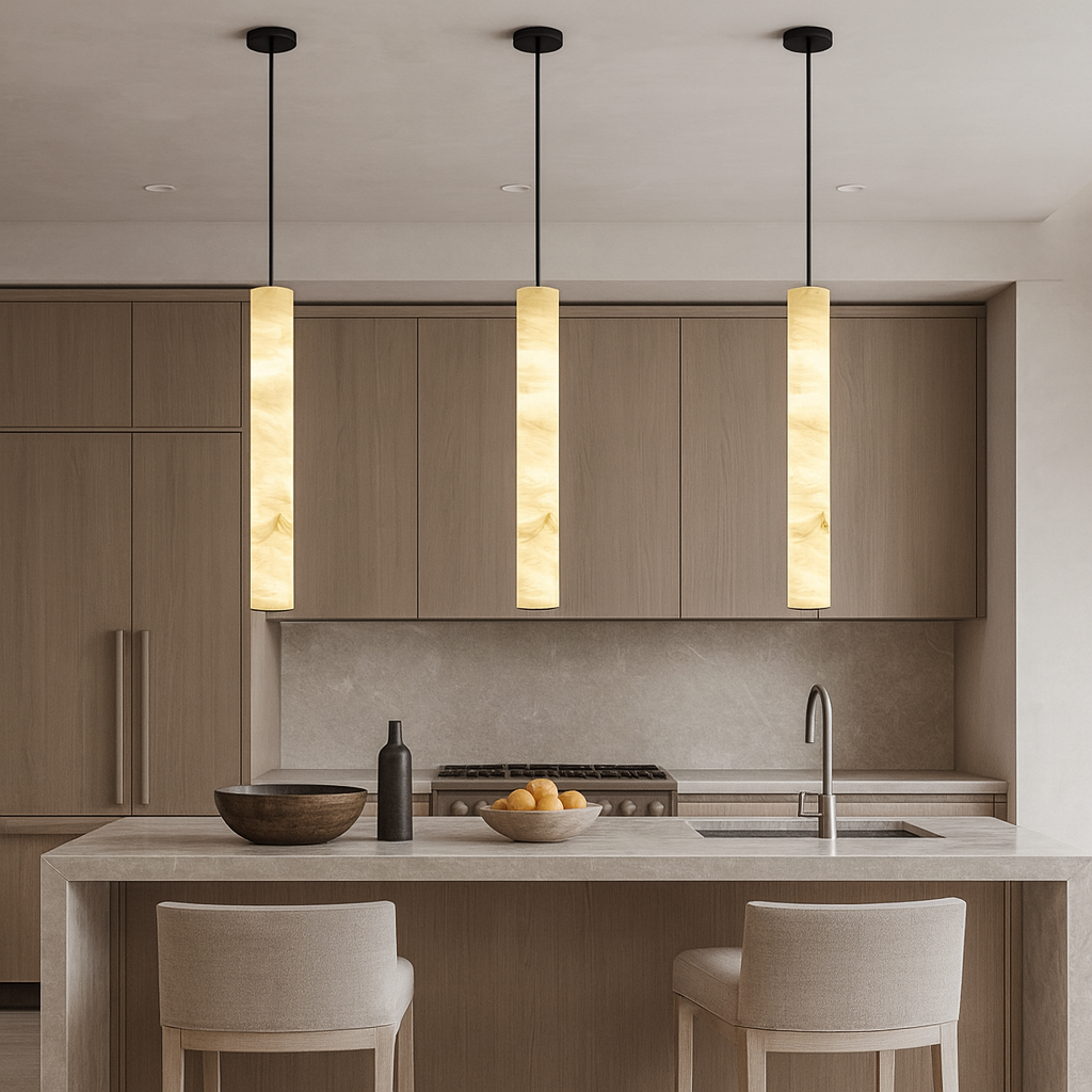 A modern kitchen featuring light wood cabinets, a matching island with two light stools, a sink, a bowl of oranges, and three Morsale Moonshade Natural Marble LED Pendants with dimmable bulbs hanging above the island.