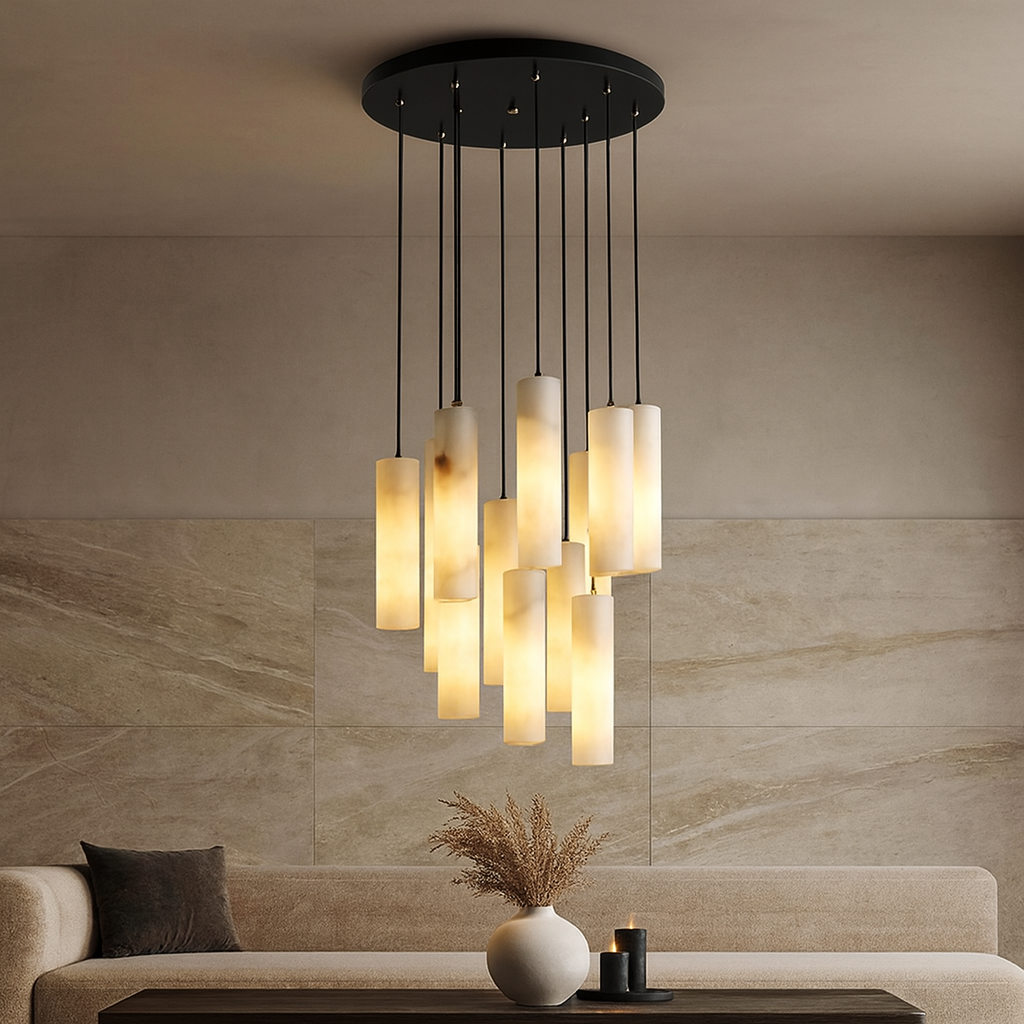 The Moonshade Marble Pendant Light Fixture by Morsale.com hangs above a neutral living room with a beige sofa, black cushion, low table, and vase of dried flowers, adding modern elegance with its luxurious cylindrical frosted glass design.