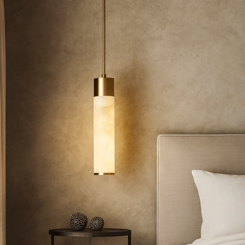 The Sorella Marble Pendant by Morsale.com, featuring a cylindrical frosted glass shade, hangs beside a beige bed. A round black side table with two decorative spheres is set against a textured neutral wall.