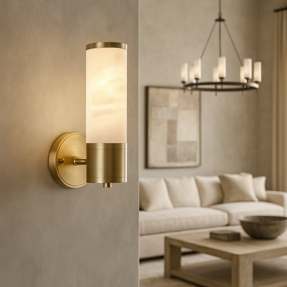 The Moonshade Natural Marble Wall Sconce by Morsale.com, with its modern design and frosted cylindrical shade, is mounted on a beige wall in a chic living room with a cream sofa, abstract art, and a round chandelier.