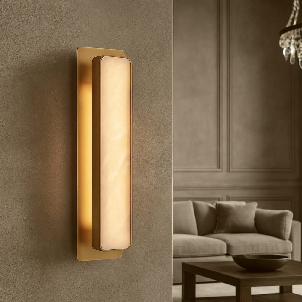 The Morsale Capri Marble Wall Sconce emits a warm LED glow against a textured beige wall, complemented by a neutral sofa, wooden coffee table, and chandelier for an inviting atmosphere.